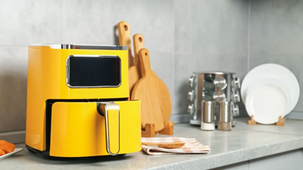 A yellow air fryer on a kitchen shelf.